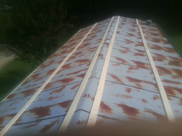 Rusted metal roof panels with new wood purlins before replacement — Storm Damage Roof Repair in Willow City by Roofing Brothers